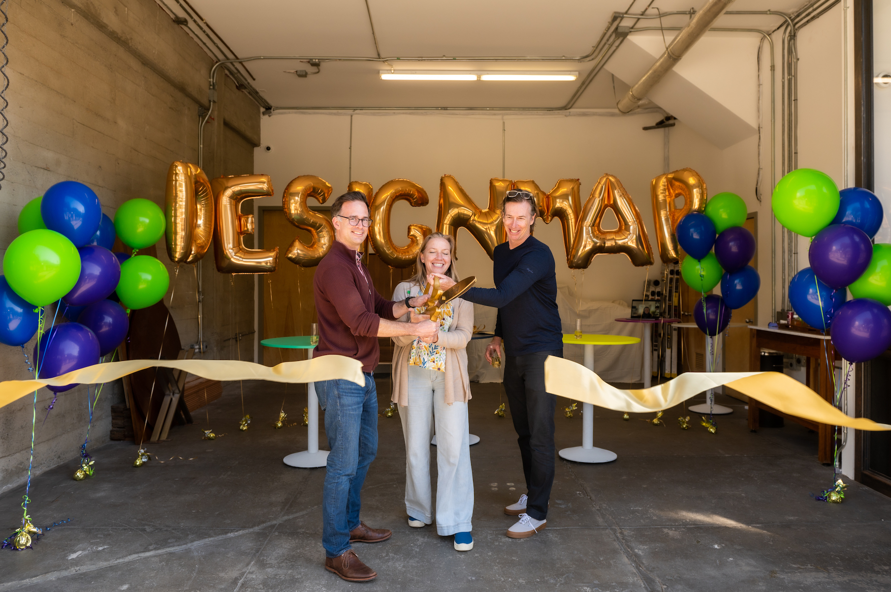 Gregory Baker, Audrey Crane and Chuck Moore cut a gold ribbon at office opening.