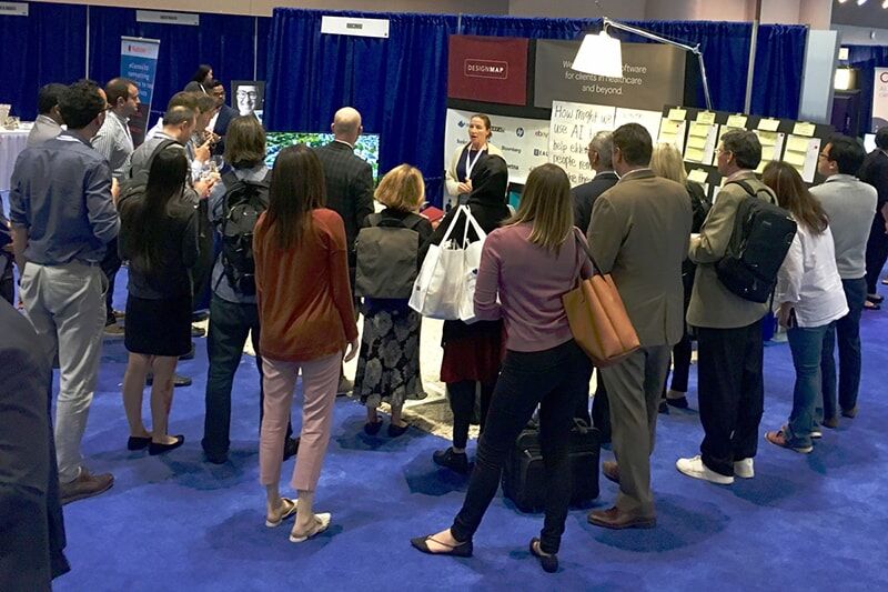 Crowd of office workers standing around a person speaking to them
